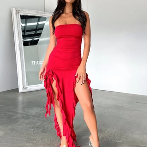 Detail of red tube maxi dress featuring asymmetrical ruffled hem and a high side slit