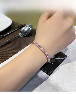 Close-up of rose gold tennis bracelet with baguette-cut zircons worn on wrist