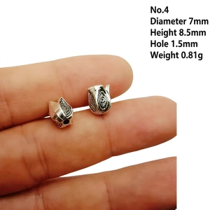 Macro shot of silver tulip flower bead caps with detailed engraving for jewelry DIY