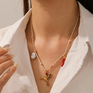 Detail of woven necklace with pearl, hummingbird and red chili charms on model