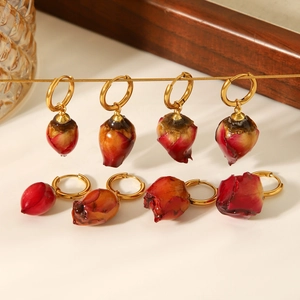 Detail showing red rose bud charms on golden stainless steel hoop earrings for women