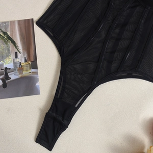 Detail of sheer black mesh bodysuit with vertical boning support and high-cut waist design