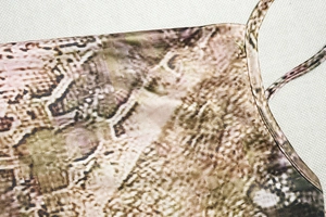 Detail shot of vintage snakeskin print fabric showing texture and strap stitching