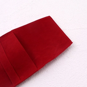 Close-up of red velvet jewelry pouch with detailed stitching and soft texture