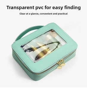 Detail of mint green makeup bag with transparent PVC window and gold zipper closure