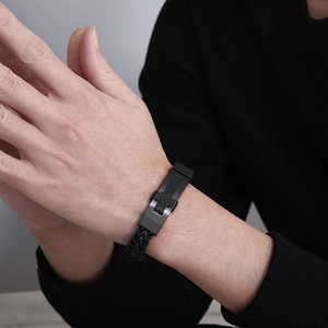 Macro shot of a black woven leather bracelet with a textured stainless steel buckle