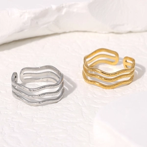 Macro detail of wave-shaped triple-layer rings with hammered metal texture