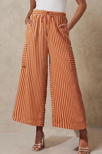 Detail of colorful vertical stripes, elastic drawstring waist and side pockets on wide-leg pants
