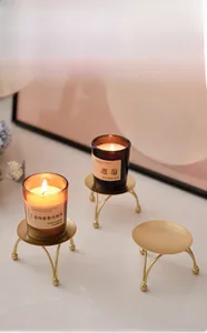 Detailed view of three minimalist golden iron candle holders for aromatherapy cups