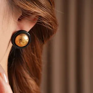 Minimalist vintage style round earrings with black enamel and hammered gold core texture