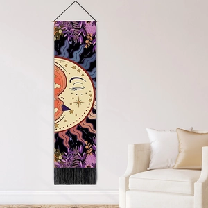 Detail of bohemian sun and moon tapestry with purple patterns and decorative black tassels