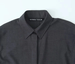 Détail de l'encolure de chemise gris foncé et étiquette XS montrant la texture du tissu