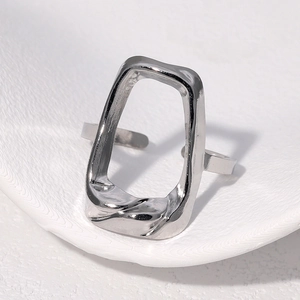 Macro detail of the silver irregular geometric cutout design on the stainless steel open ring
