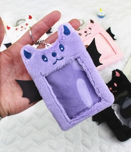 Detail view of plush bat-winged photo card holders with metal keychains in multiple colors