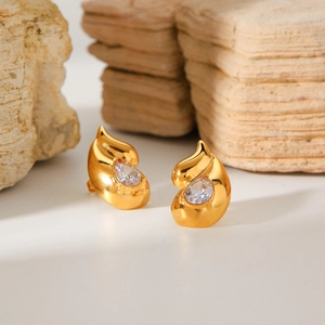 Detailed view of gold water drop stud earrings with pear-cut crystals on a natural stone
