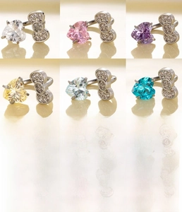 Macro view of C-shaped titanium steel horseshoe rings with colorful zircon hearts and bows
