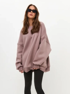 Detail of oversized mauve sweatshirt showing ribbed cuffs and soft fleece fabric texture