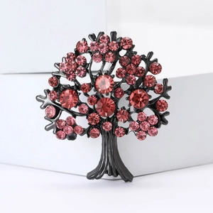 Detailed close-up of tree brooch with pink and red rhinestones on black metal base