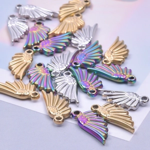 Détail de pendentifs d'ailes d'ange en acier inoxydable en tons or, argent et arc-en-ciel