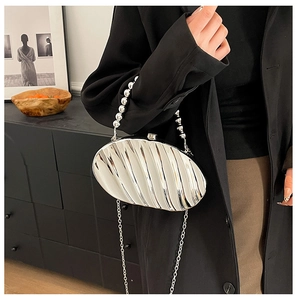Silver metallic leaf-shaped clutch with shell texture and elegant pearl handle detail