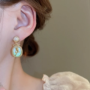 Close-up of vintage tulip earrings with pearls and gold-plated floral oval pendants