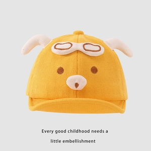 Close-up of bright yellow baby knit hat with aviator puppy ears and goggle embroidery