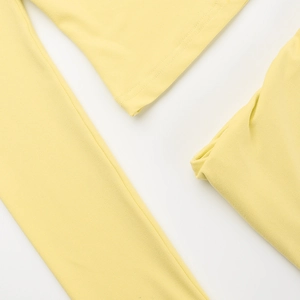 Detail view of smooth light yellow knit fabric with premium stitching and fine texture