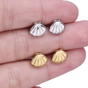 Detailed comparison showing size of gold and silver seashell stud earrings in hand