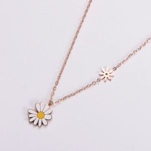 Rose gold daisy necklace featuring white enamel sunflower charms on a clean white backdrop