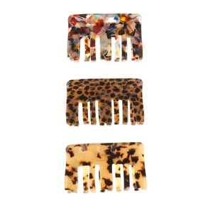 Detailed top view of three acetate hair claws in floral, tortoiseshell, and marble patterns