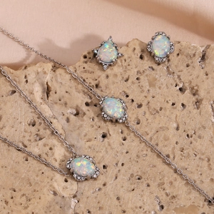 Details des silbernen Opal-Schmucksets mit Halskette und Armband auf Steinoberfläche