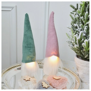 Close-up of glowing Christmas gnomes with long beards and velvet hats on silver tray
