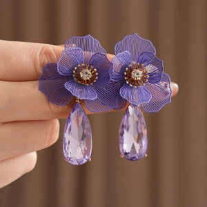 Detailed view of flower earrings with purple waterdrop crystals and sparkling rhinestones