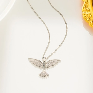 Close-up of a silver phoenix necklace with zircon insets on a white background