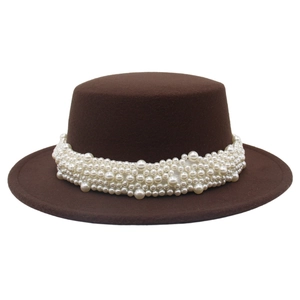 Détail d'un chapeau de feutre marron orné d'un ruban de perles blanches élégantes et chic