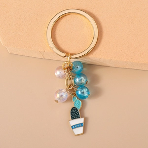 Close-up of beaded cactus keychain with pink and blue beads and golden ring detail