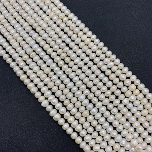 Macro shot of white natural freshwater pearls with lustrous finish on black fabric