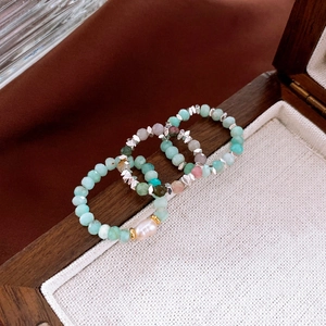 Macro shot of three stacked elastic rings with freshwater pearls and amazonite stones