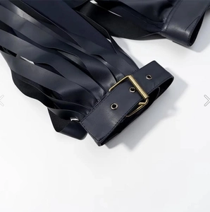 Close-up of black PU leather jacket featuring vintage brass eyelets and metal buckles