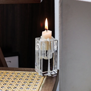 Minimalist clear glass square pillar candle holder with burning white pillar candle