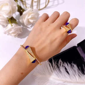 Close-up of gold double pagoda bracelet and ring set with purple stones and diamonds