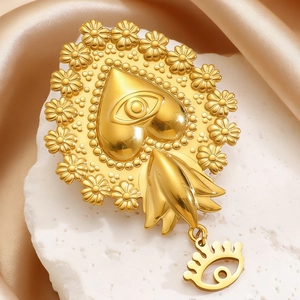 Detailed macro of a vintage golden Sacred Heart brooch with Evil Eye and daisy petals
