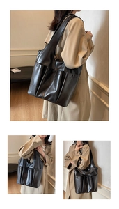 Detail of black soft leather tote bag showing multi-pocket design and smooth texture