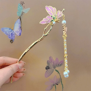 Detail of butterfly hair stick with purple wings, pearls and long golden tassels
