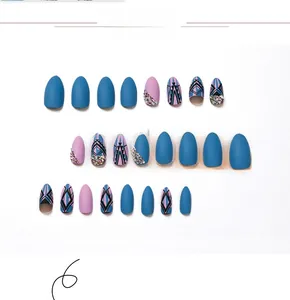 Vue détaillée de faux ongles mats bleu et violet avec motifs géométriques et strass brillants