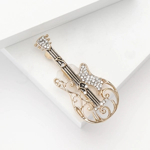 Elegant gold-tone guitar brooch with sparkling white crystals and intricate hollow details