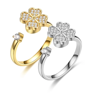 Vista detallada de anillos de acero inoxidable con trébol de cuatro hojas en oro y plata
