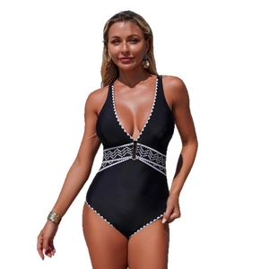 Deep V-neck one-piece swimsuit in black with white geometric patterns and wave edges