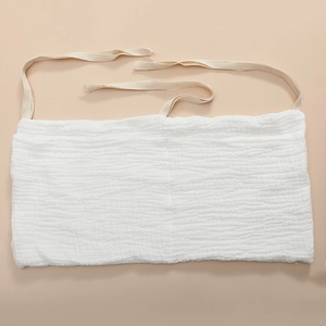 Detail of white cotton crib organizer showing soft gauze texture and secure tie straps