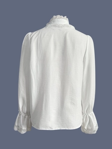 Detail of white lace stand collar and ruffled cuffs on long-sleeve chiffon blouse back